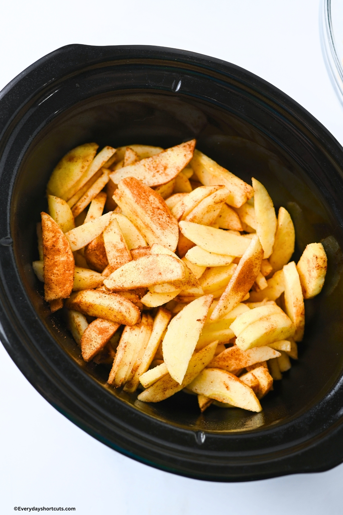 peeled and sliced apples with spices in a crockpot