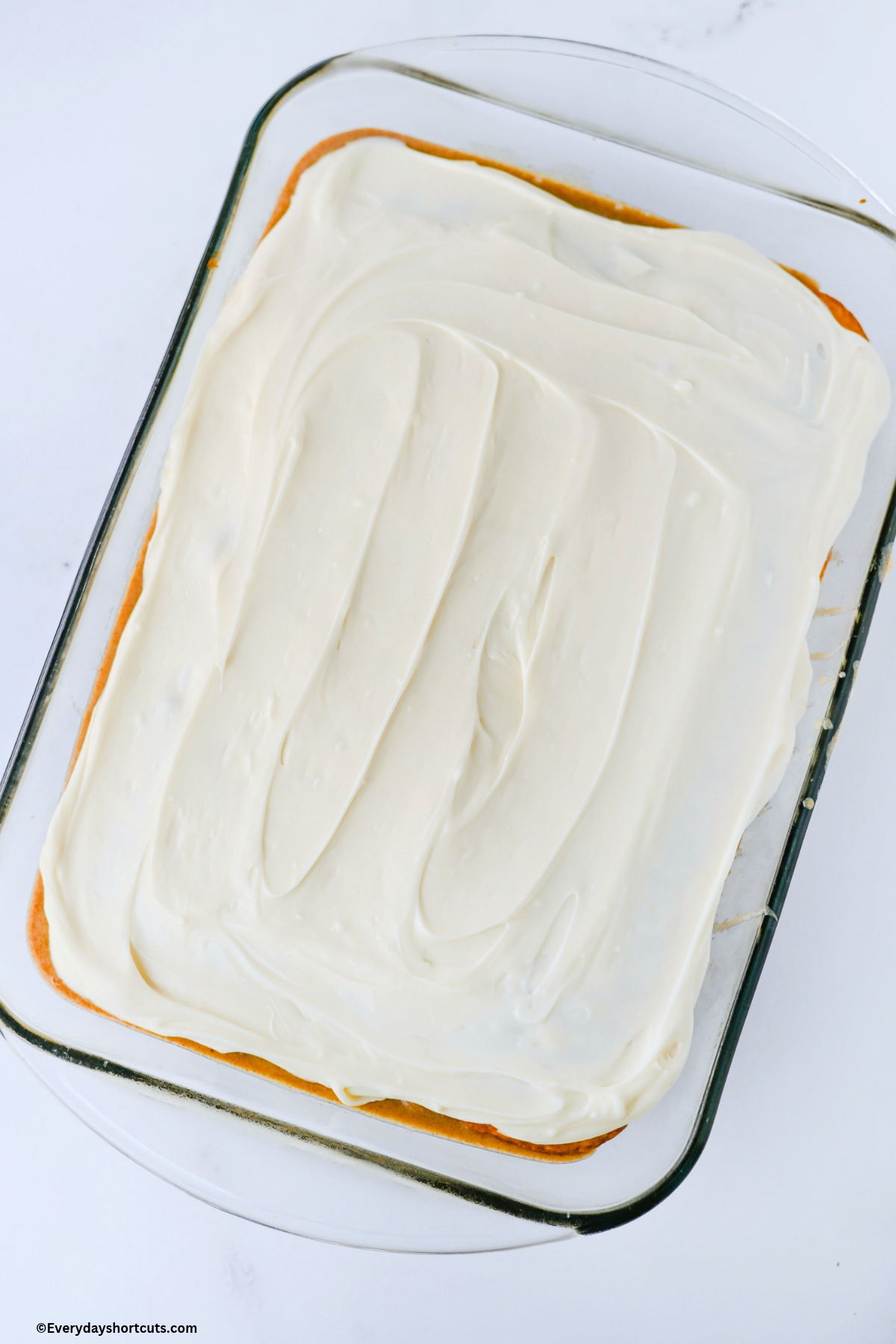 frosted vanilla cake in baking dish
