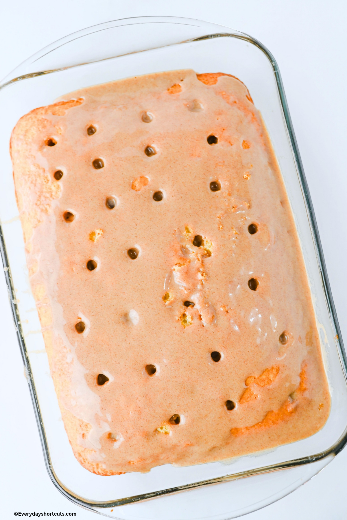 cinnamon roll mixture poured on top of cake with holes