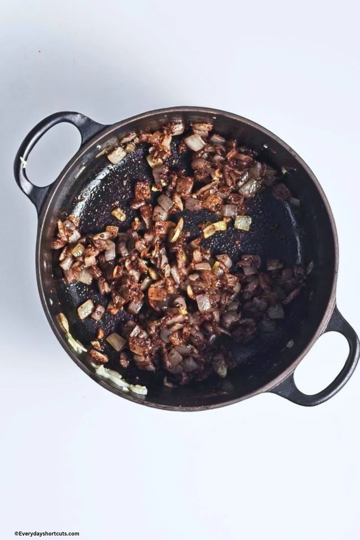 onion and minced garlic cooked with nutmeg, cinnamon and black pepper in a pan