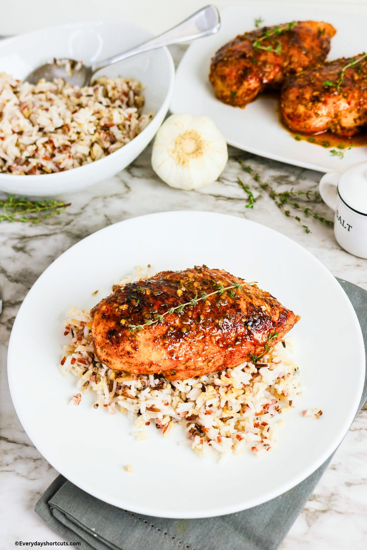 baked chicken breast with maple glaze on top and on a bed of rice on a white plate