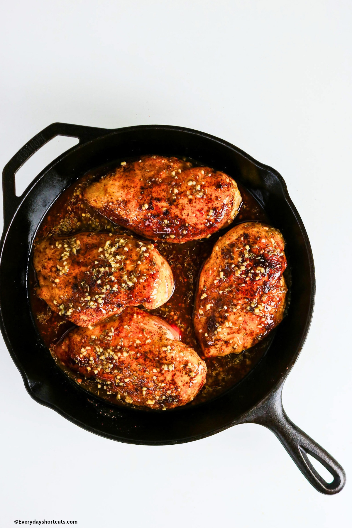 chicken breasts in a cast iron skillet with mustard glaze over top