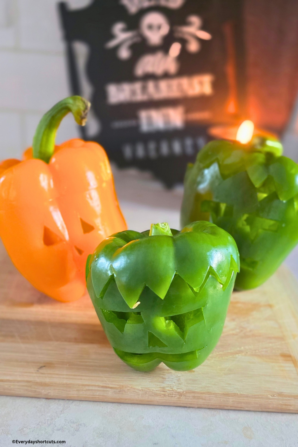 Frankenstein and Jack O'Lantern faces carved in peppers