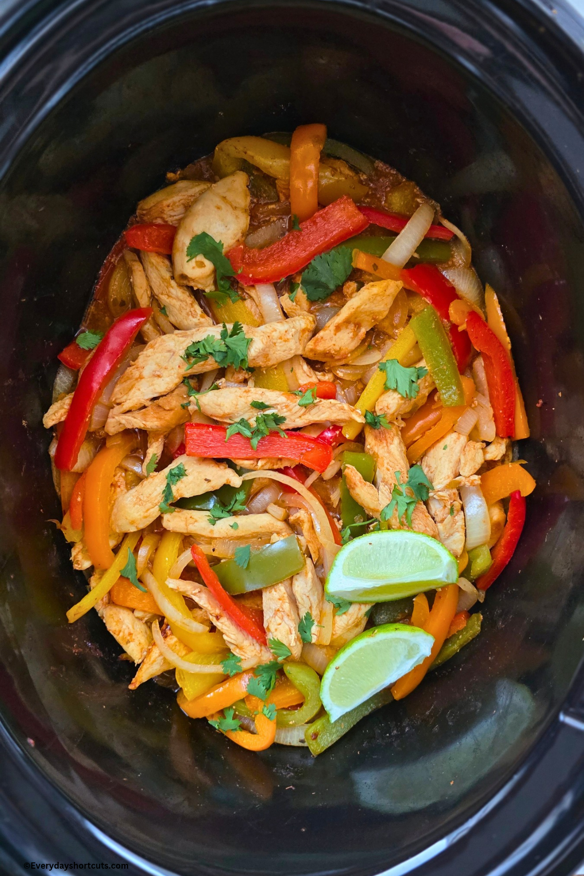 chicken fajitas ingredients in crock pot with 2 lime wedges on top