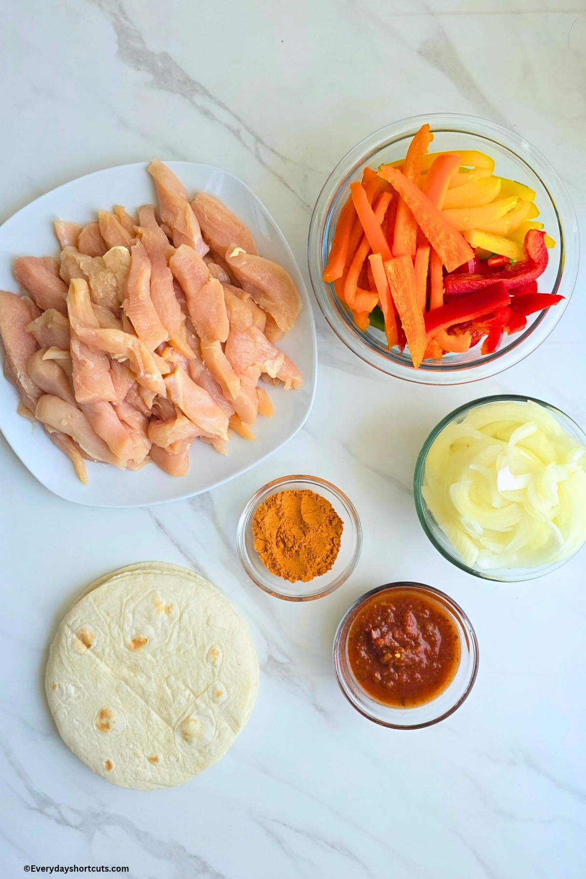ingredients shown: chicken cut into strips, bell peppers sliced, onions sliced, fajita seasoning, salsa and flour tortillas