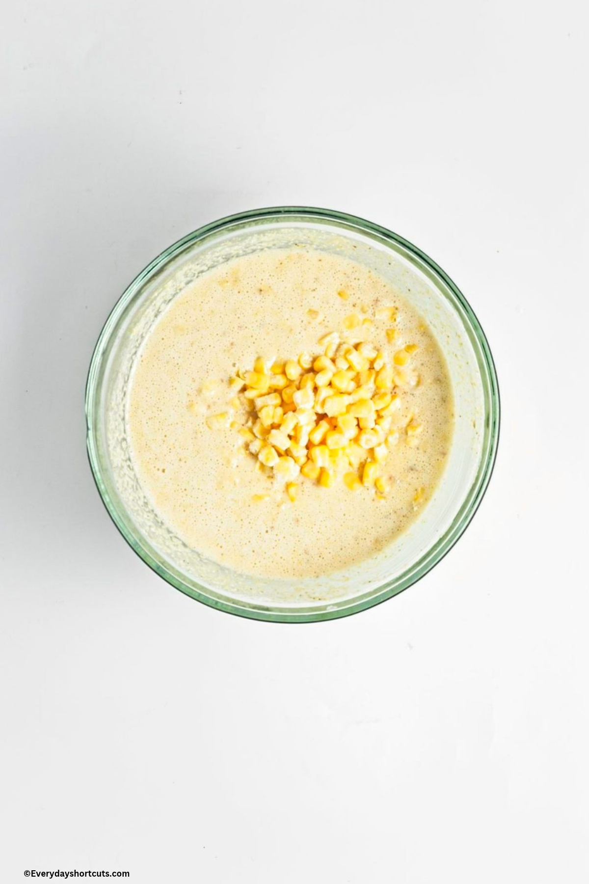corn kernels on top of cornbread batter in bowl