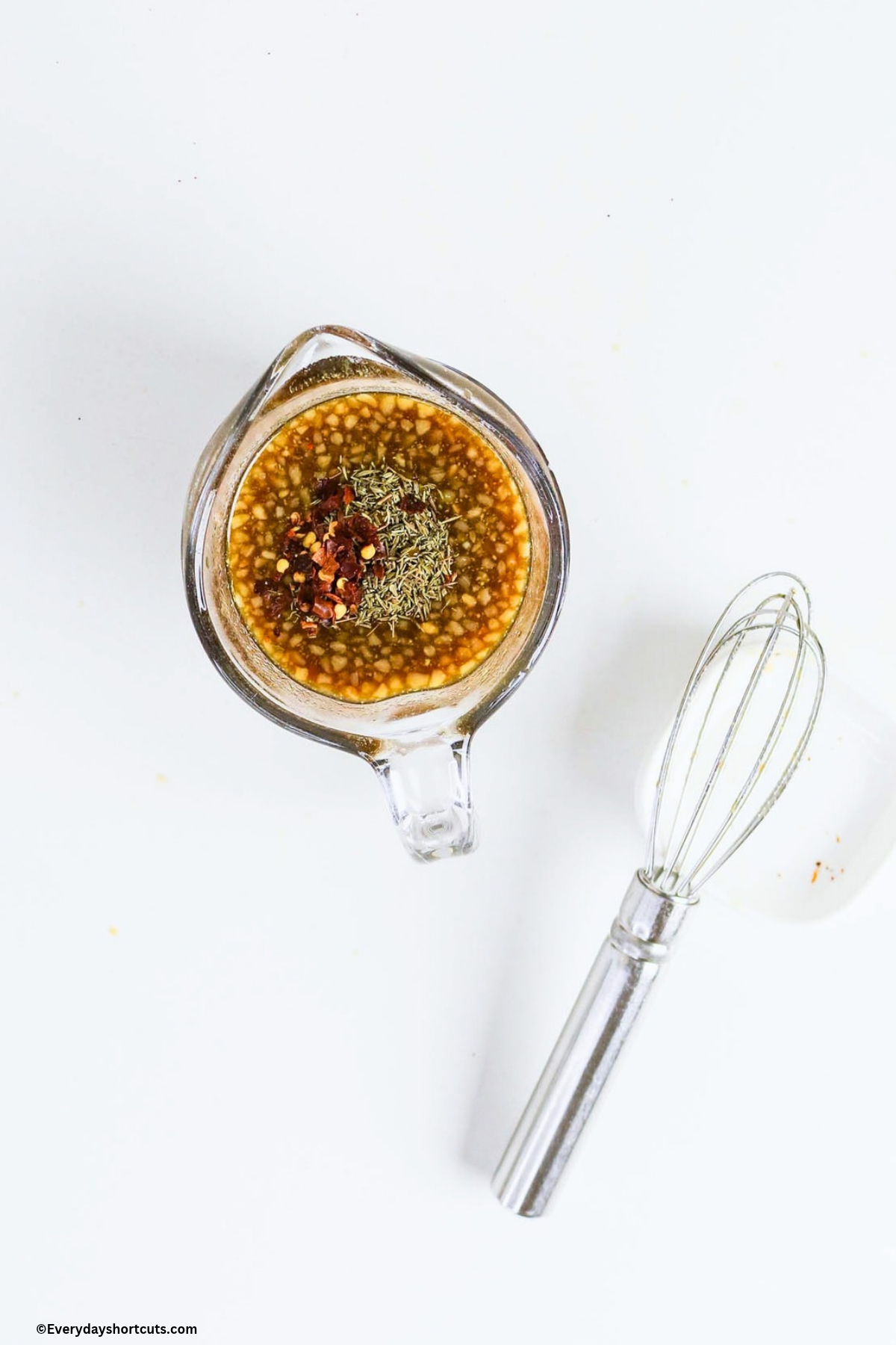 maple dijon glaze in a measuring cup next to a whisk